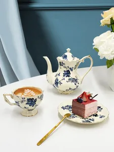 Dettaglio di teiera e tazza vintage in ceramica con rose blu e rifiniture in oro