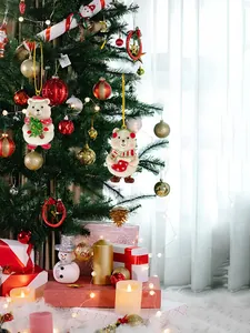 Detail of resin Christmas bear ornaments with red hats and scarves on festive tree