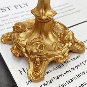 Macro view of vintage gold candlestick base featuring exquisite rose floral relief details