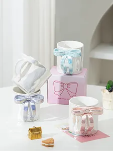 Dettaglio tazza in ceramica iridescente con manico a fiocco rosa e confezione regalo coordinata