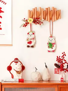 Detail of cute white bear Christmas ornaments with red scarves on a wooden wall hook