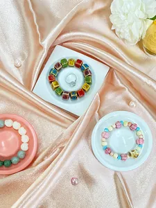 Flat lay of colorful beaded bracelets and a silver ring on elegant resin display trays