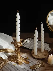 Goldener Kerzenhalter mit weißen Spiralkerzen in einer Vintage-Atmosphäre