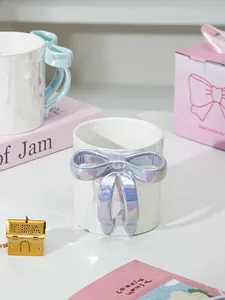 Dettaglio di tazze in ceramica con fiocco perlato in confezione regalo decorata