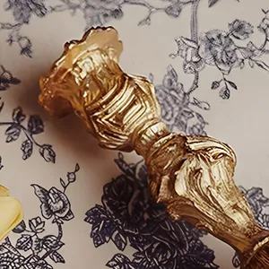 Detail of golden Baroque candle holder featuring intricate vintage relief textures