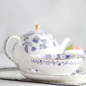 Dettaglio di tazzina in ceramica bianca con motivi floreali blu e bordo dorato