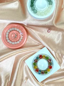 Detailed display of resin jewelry trays with beads bracelets and a silver diamond ring