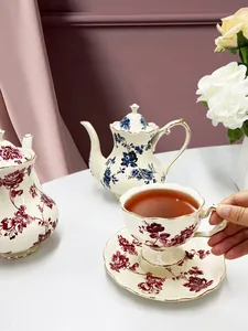 Dettaglio del set da tè vintage in ceramica con motivi di rose e bordi dorati in oro