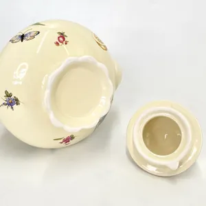 Detail of floral ceramic teapot base and lid with elegant wavy rim and glazed finish