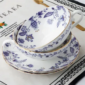 Dettaglio di tazzine da caffè in ceramica a fiori viola con bordo dorato e piattini