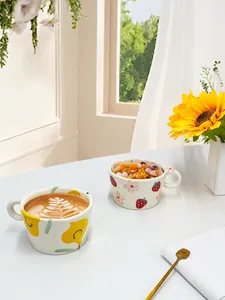 Detalle de tazas de cerámica de fresa y limón con arte latte y fondo muy soleado