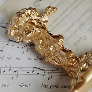 Detailaufnahme des goldenen Kerzenhalters im Vintage-Stil mit geschmolzener Lavatextur