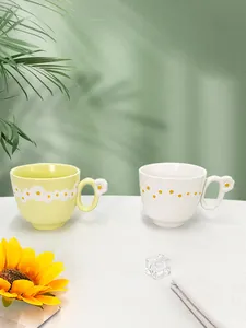 Close-up of handmade ceramic daisy mugs featuring 3D floral handles and embossed petals