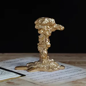 Makroaufnahme goldener Vintage-Kerzenhalter mit organischer Textur auf Holztisch
