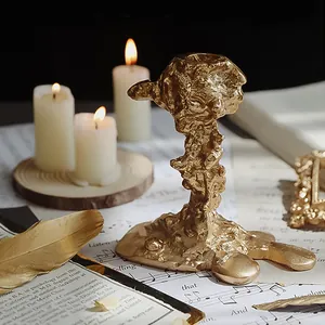 Makro-Detail von goldenem unregelmäßigem Kerzenhalter mit Metalltextur und Vintage-Büchern