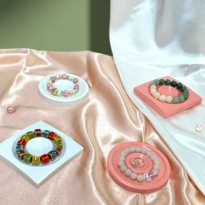 Resin jewelry tray set featuring various beaded bracelets and a silver ring on silk fabric