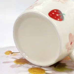Detalle de taza de cerámica de fresa con motivos florales pintados a mano y lisos