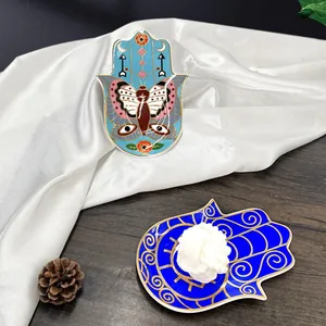Details von Hamsa-Hand-Keramiktabletts mit Mustern und floraler Kerzendekoration