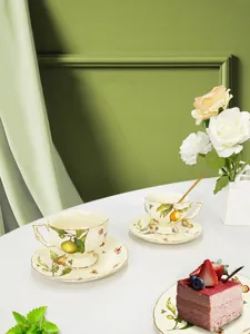 Close-up of vintage ceramic coffee set with citrus patterns and elegant gold trim