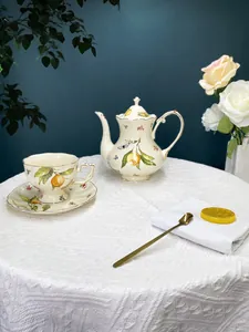 Detailed view of an elegant vintage ceramic tea set with lemon floral pattern and gold rim