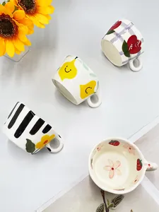 Vista detallada de cuatro lindas tazas de cerámica 3D con patrones de fresas y limones pintados a mano