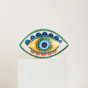 Detalle de decoración de ojo turco en cerámica con bordes dorados y patrones vibrantes