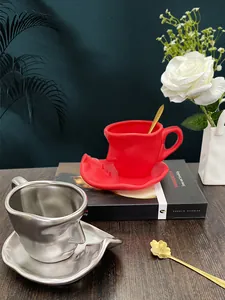Artistic face relief ceramic coffee cup set in matte red and silver with golden spoons