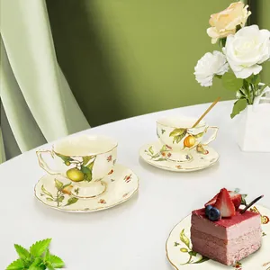 European vintage ceramic tea set with lemon pattern and gold trim on a white table