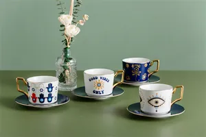 Set di tazze da caffè in ceramica con motivi Malocchio, manici dorati e piattini blu