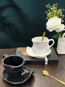 Artistic face-shaped ceramic coffee cup set with gold spoons and matching saucers