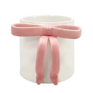 Cute 3D pink bow ceramic coffee mug with minimalist aesthetic on white background
