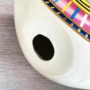 Vista de detalle de decoración nórdica de cerámica con borde dorado y rayas de colores