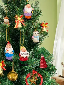 Close-up of resin Christmas gnome and holiday tree ornaments hanging on a green festive tree