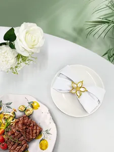 Dettaglio dell'anello portatovagliolo a fiore in smalto bianco con finitura oro