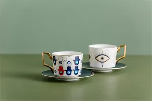 Dettaglio di tazzine da caffè in ceramica con motivo malocchio blu e bordi dorati