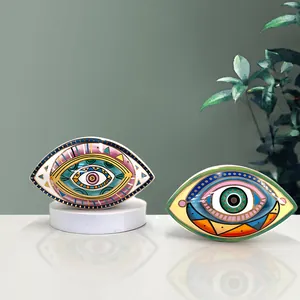 Detalle de dos adornos cerámicos de ojo turco con bordes dorados y patrones bohemios