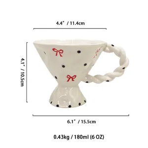 Hand-painted vintage ceramic coffee mug with bow and dots, irregular stemware design