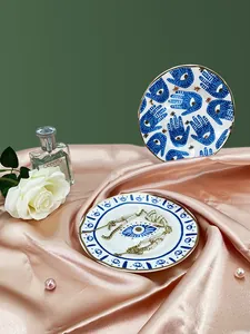 Détail de plateaux à bijoux en céramique avec motifs d'œil bleu et bordures dorées