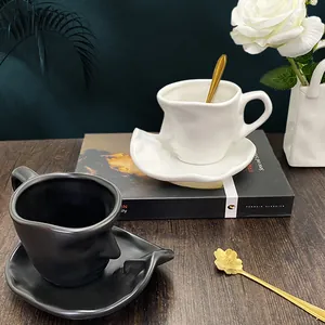 Artistic face silhouette ceramic coffee cup and saucer set with gold spoon on wooden table
