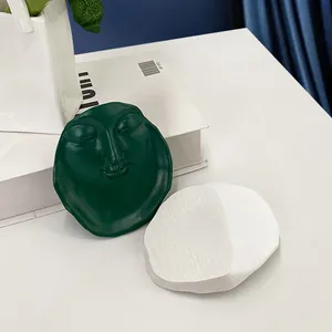 Close-up of creative resin face tray and textured white base for home decor display