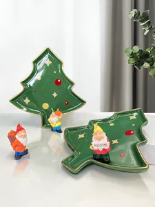 Detail of Christmas tree ceramic trays with gnome figurines and golden rim decor