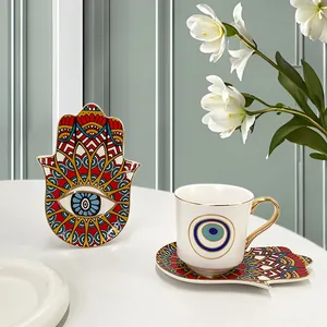 Dettaglio della tazzina da caffè in ceramica con motivo Evil Eye e manico dorato