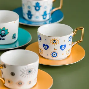 Dettaglio macro della tazzina da caffè in ceramica malocchio con manico oro e piattino