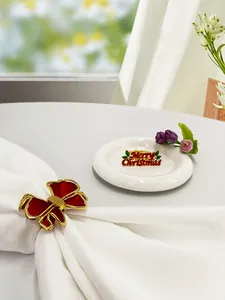 Dettaglio del portatovagliolo con fiocco rosso e decorazione Merry Christmas