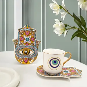Dettaglio del set da caffè in ceramica con motivo Hamsa e finiture dorate artigianali