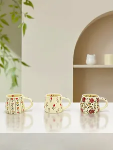 Detailed view of three ceramic mugs with tulip, rose, and leopard print floral patterns