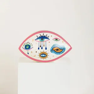 Detail of Nordic evil eye ceramic jewelry tray with gold edge and artistic patterns