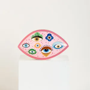 Macro detail of Nordic gold-rimmed ceramic evil eye jewelry tray for home decor