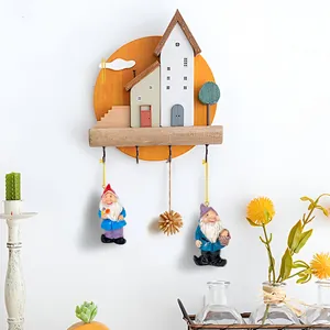 Christmas wall hanging featuring resin gnomes and house miniature on a round base