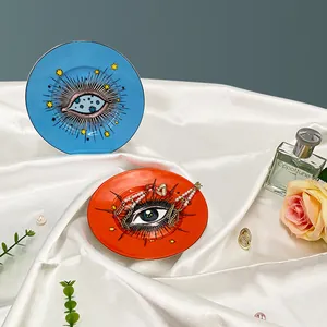 Plateau à bijoux nordique en céramique avec motif œil et étoile sur fond de soie blanche